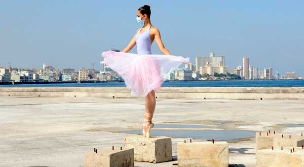 Bailarina de ballet en puntas sobre un bloque, en el Malecón