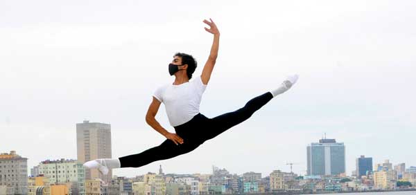 Bailarín de ballet ejecuta impresionante salto y parece suspendido en aire, con La Habana de fondo